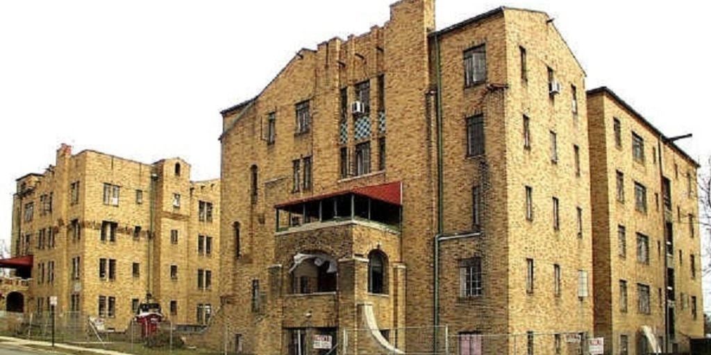 A large brick building with a lot of windows on a white background.