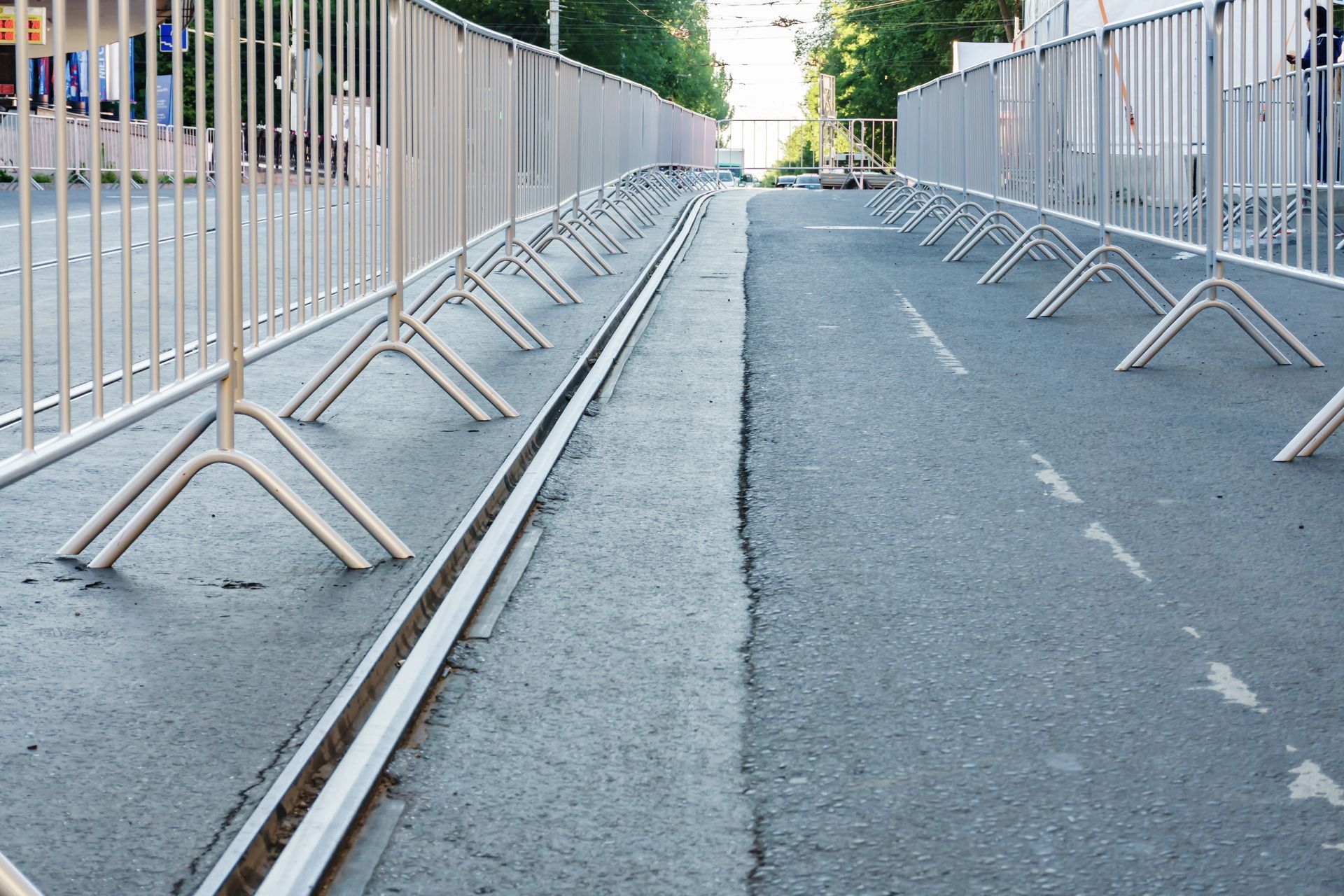 Temporary metal barricades lining a closed roadway to guide pedestrian flow and control access. Temporary metal barricades lining a closed roadway to guide pedestrian flow and control access.