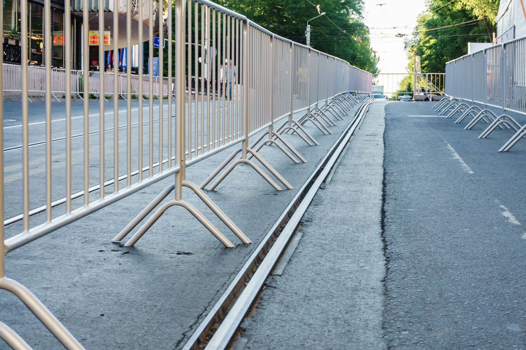 Portable metal grilles of light gray color for the organization of the queue for the event.
