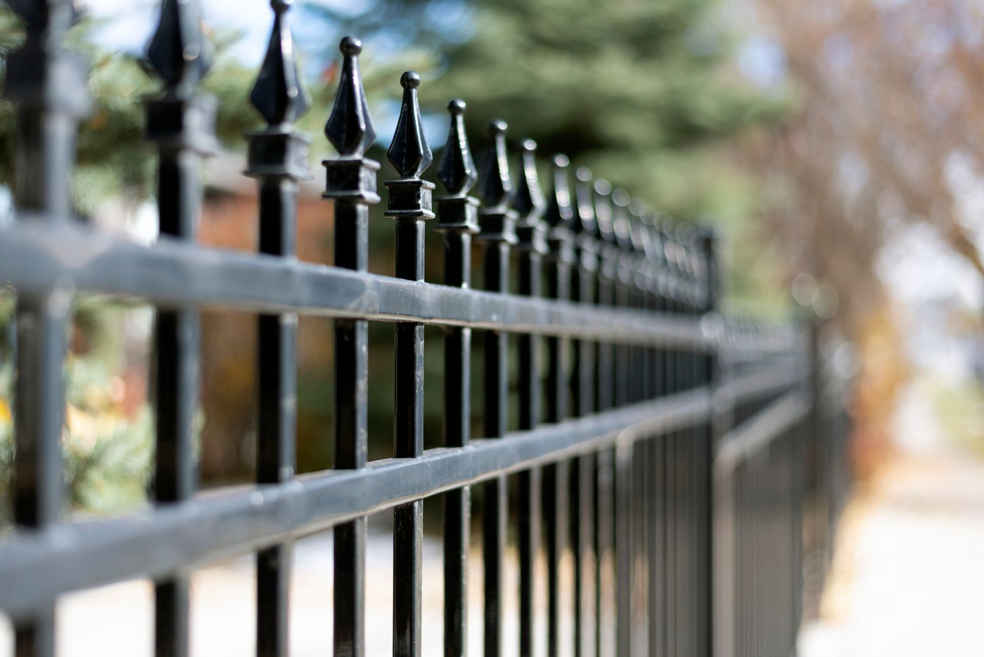 Black ornamental iron fence, with decorative finials, providing security and elegance. 