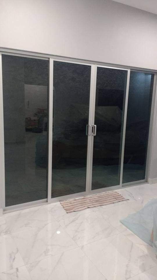 Puertas dobles de cristal enmarcadas en madera oscura en la entrada de un edificio moderno.