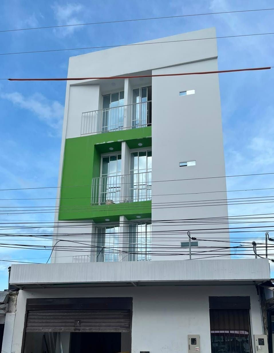 Fachada moderna de edificio de oficinas acristalada con ventanas reflectantes y estructura metálica.