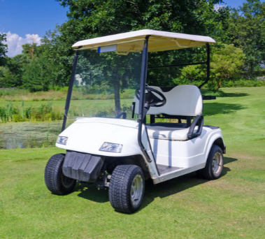 A white golf cart is parked on a lush green golf course.