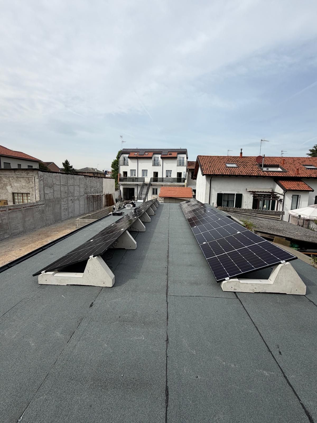 Tetto con file di pannelli solari su un tetto piatto grigio in una zona residenziale