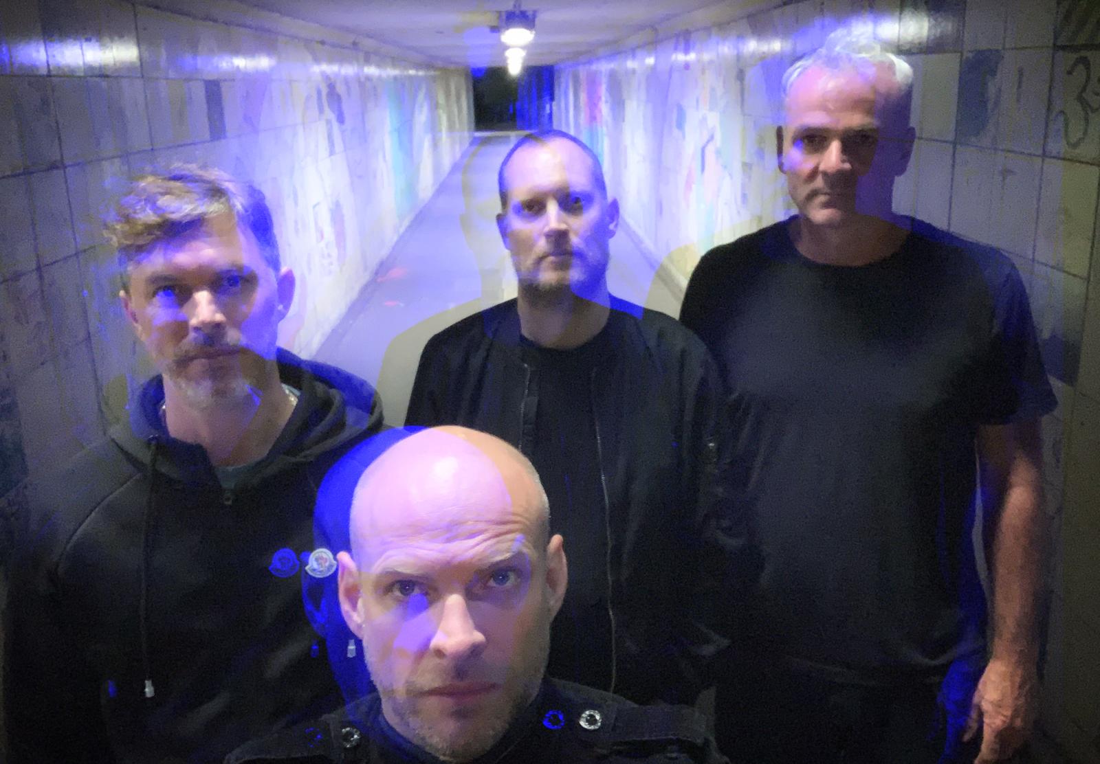 A group of men are standing next to each other in a tunnel.