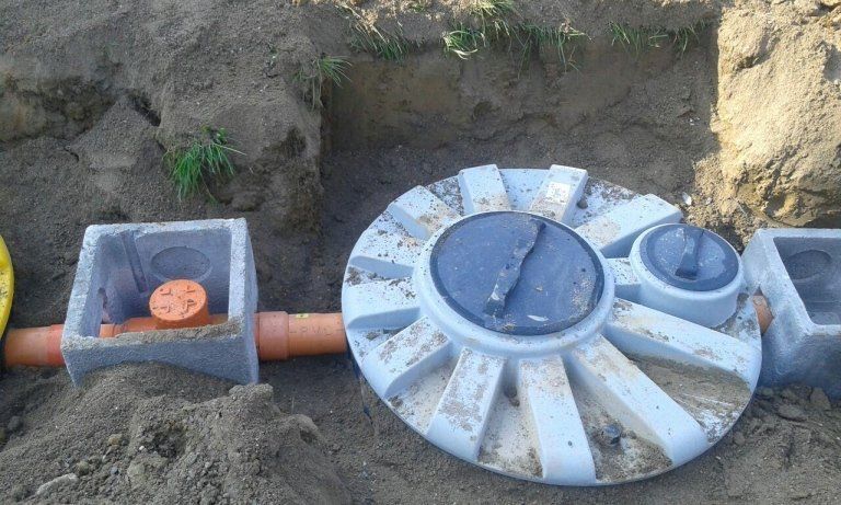 Un oggetto circolare è appoggiato sopra un mucchio di terra.