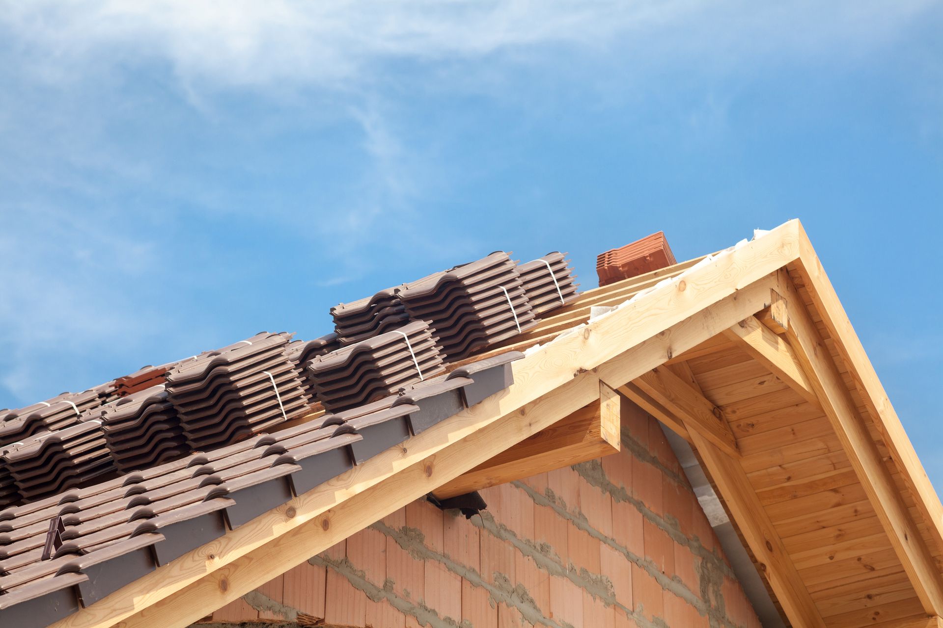 A roof of a house under construction with a blue sky in the background.