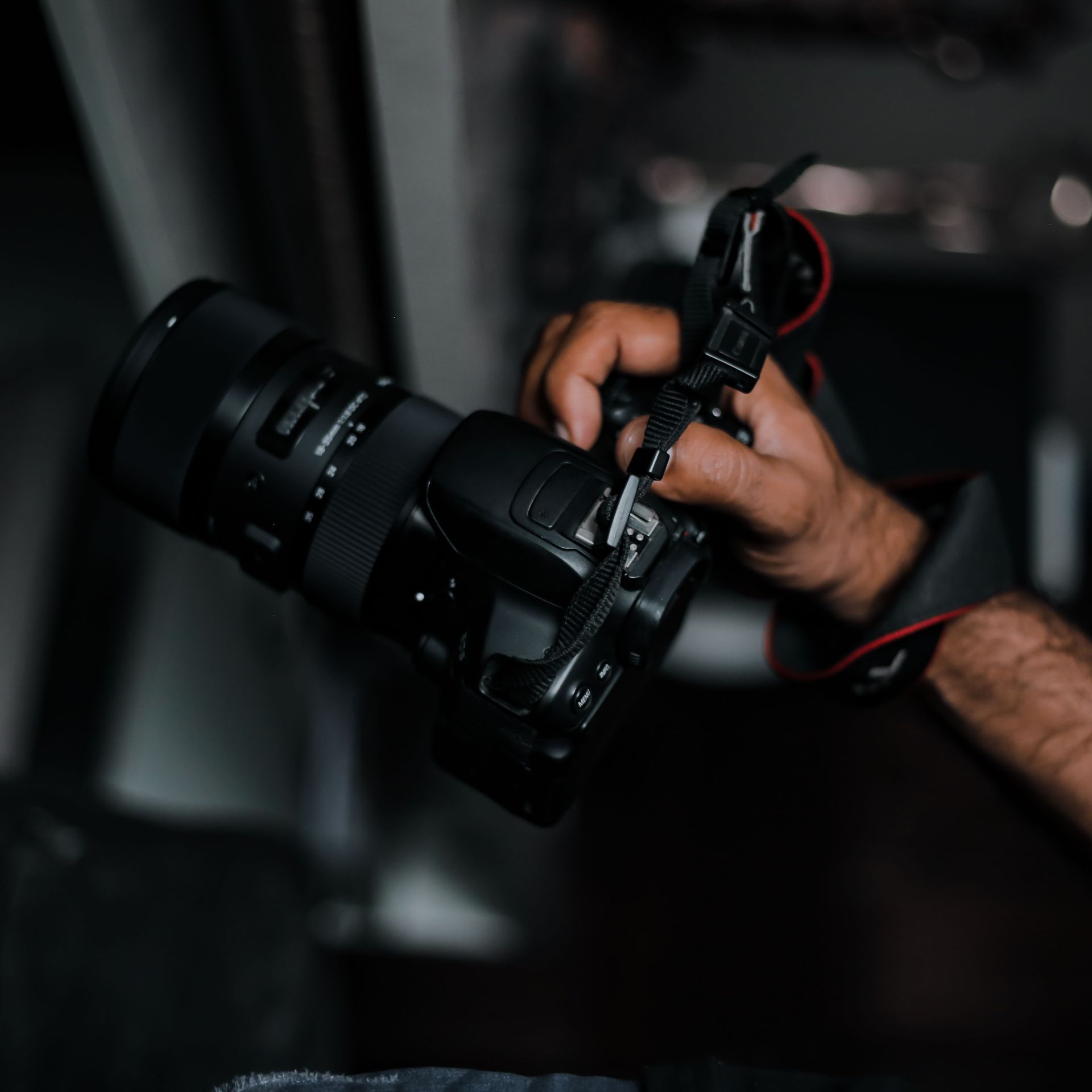 Close-up of a person adjusting a black camera rig in a dark setting
