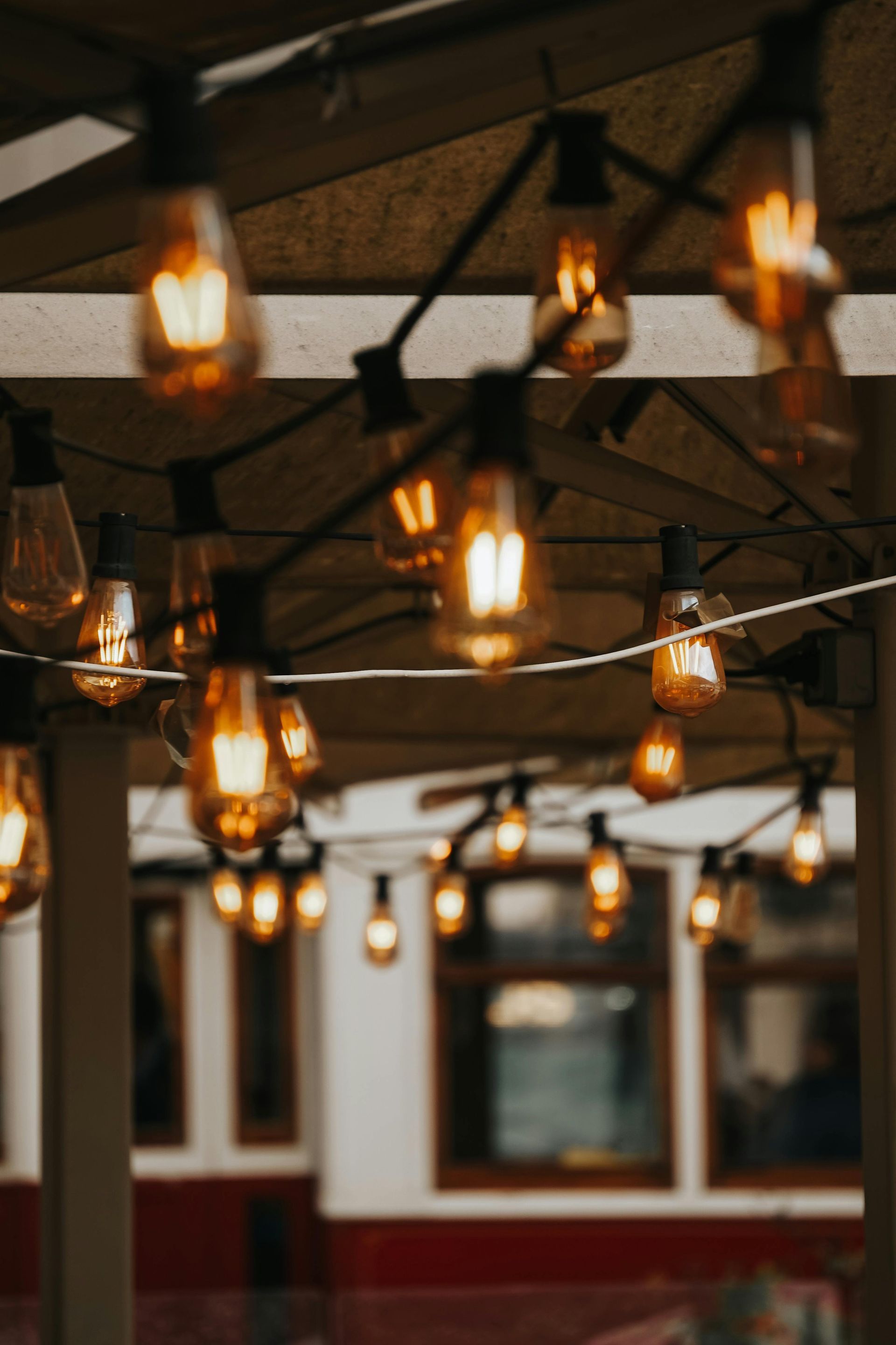 A bunch of lights are hanging from a string under an umbrella.
