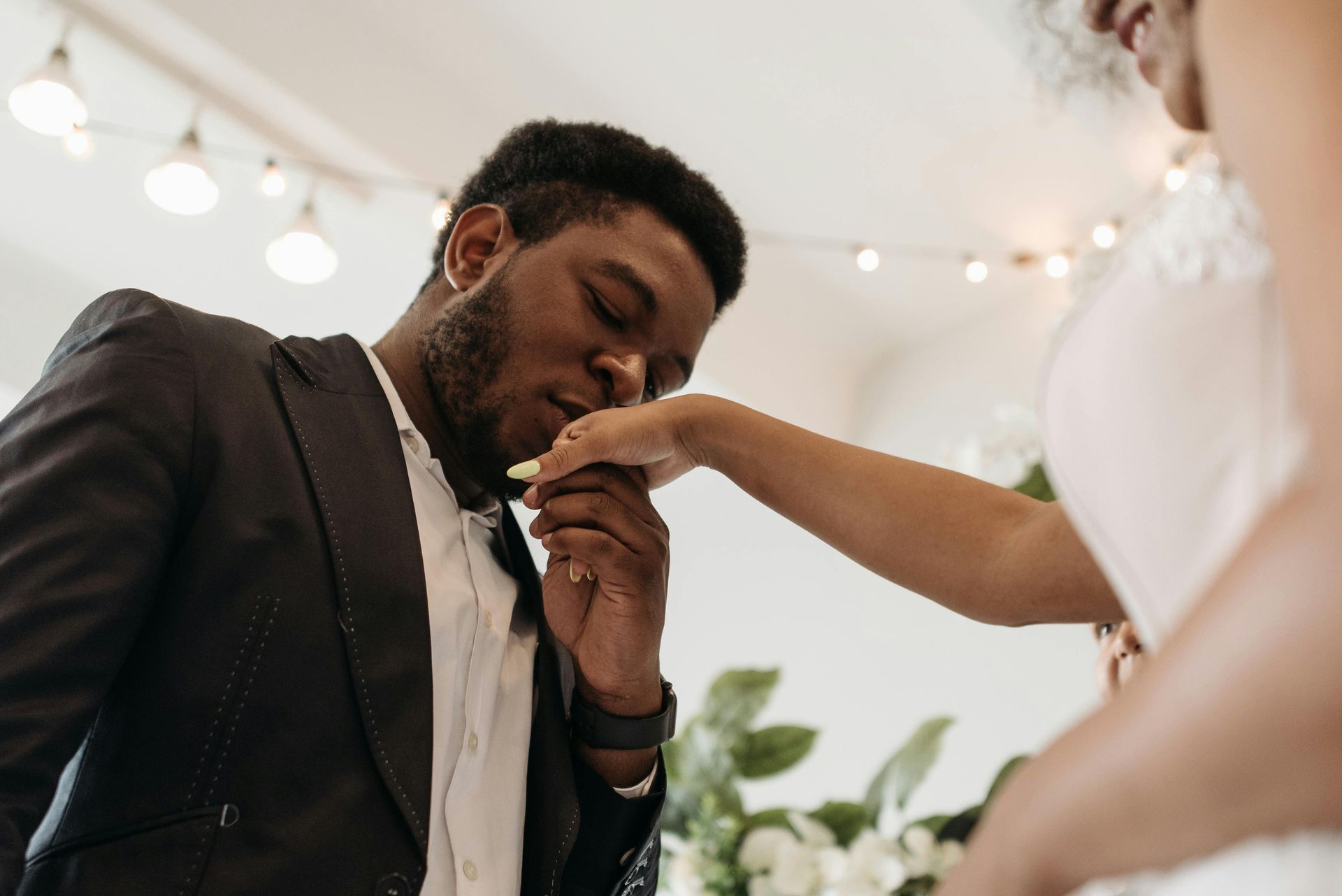 A bride is feeding a groom a piece of cake.