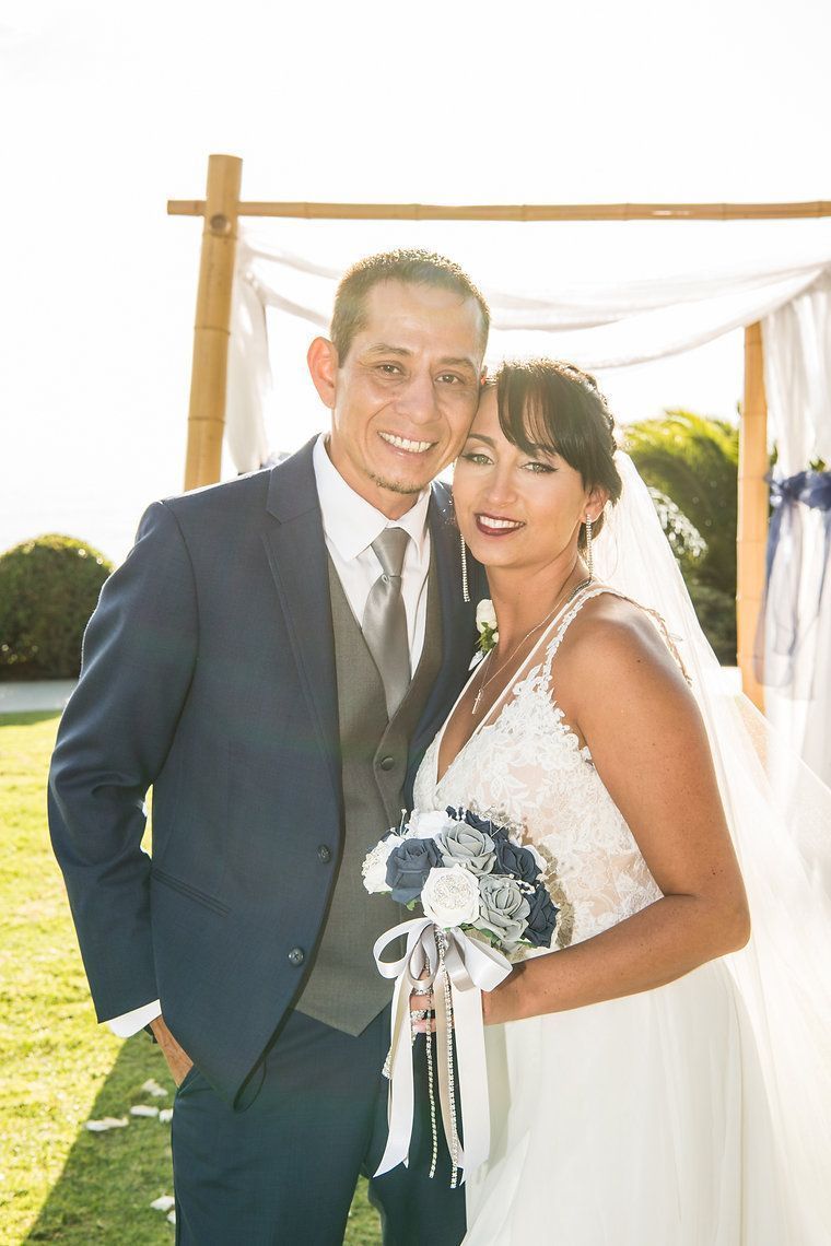 A bride and groom are posing for a picture at their wedding.