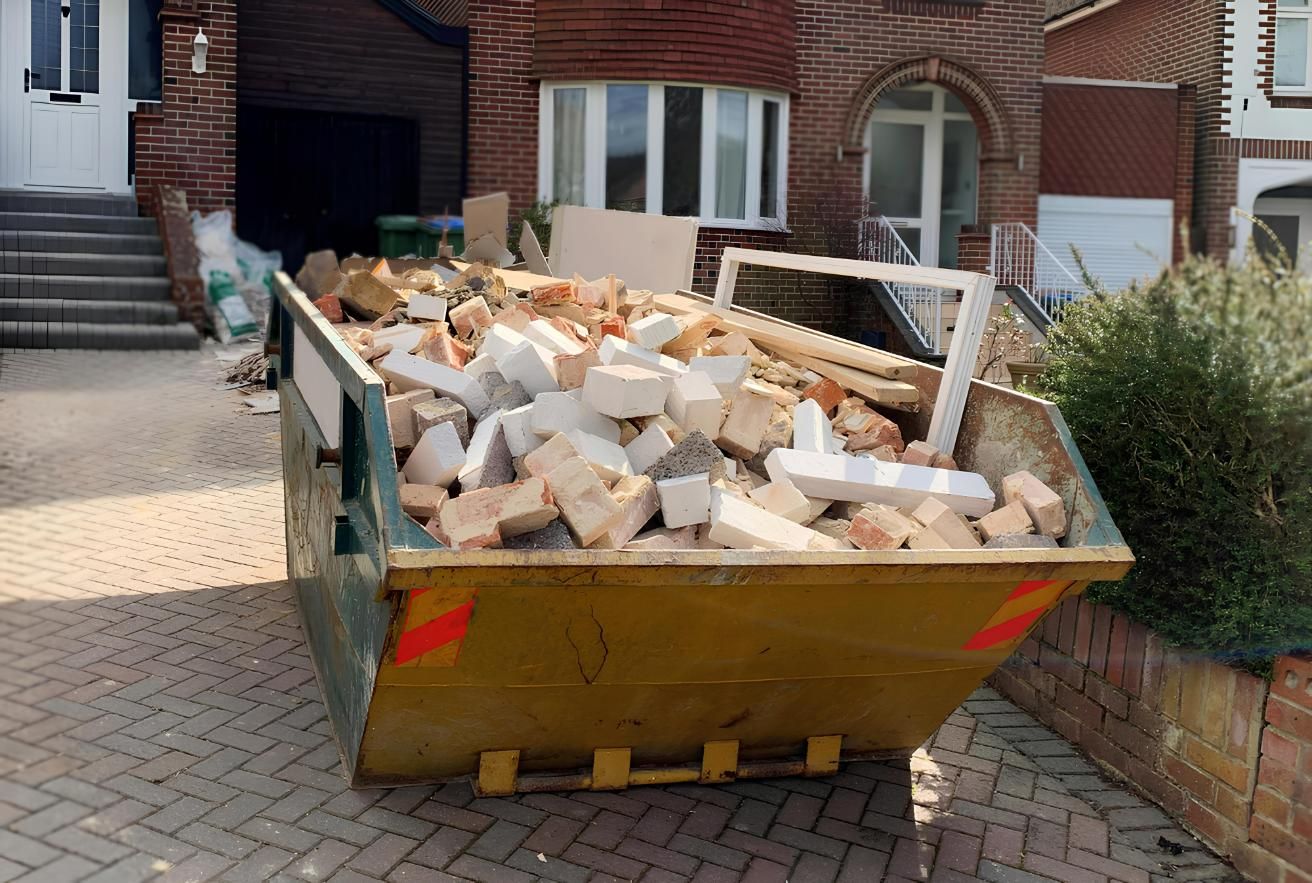 A Dumpster Filled With Bricks is Parked in Front of a Brick House — I.B.S Skip Bins in Mapleton, QLD