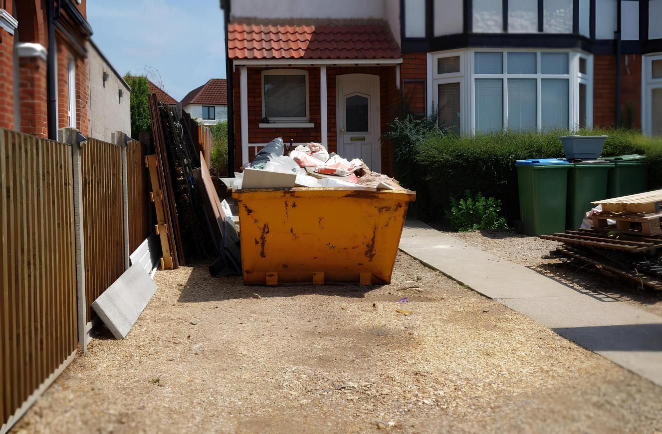 A Yellow Dumpster is Sitting in Front of a House — IBS Skip Bins in Currimundi, QLD