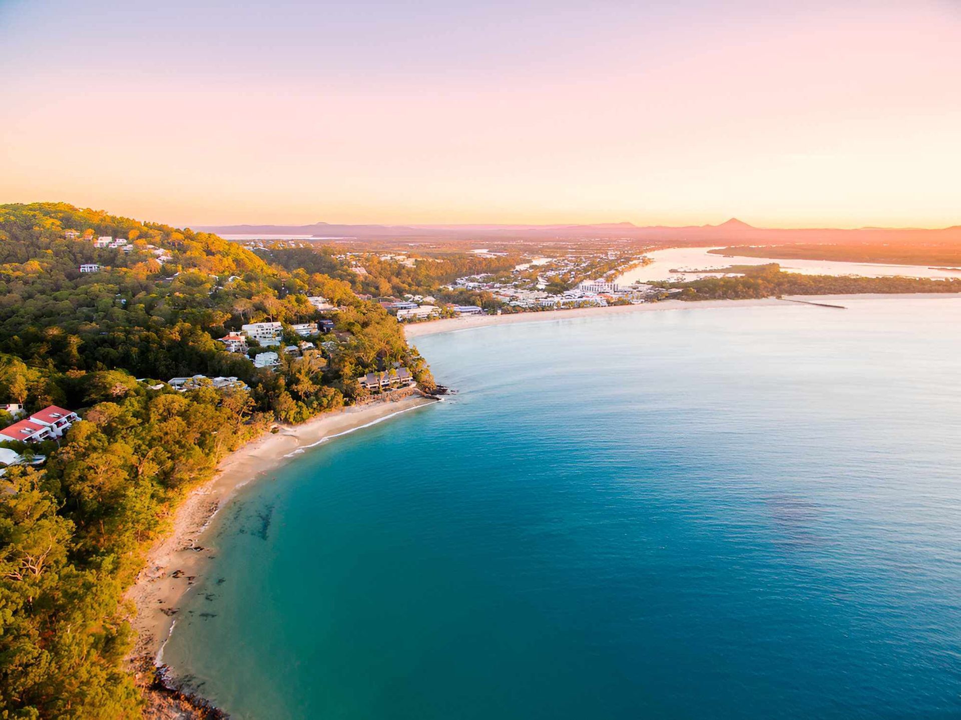 An Aerial View of a Beach and a Body of Water at Sunset — IBS Skip Bins in Noosa, QLD