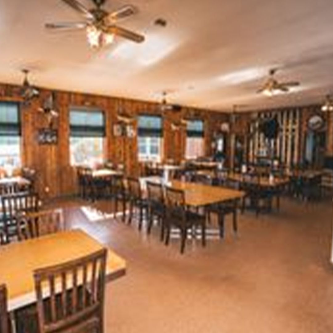 a restaurant with tables and chairs and a ceiling fan