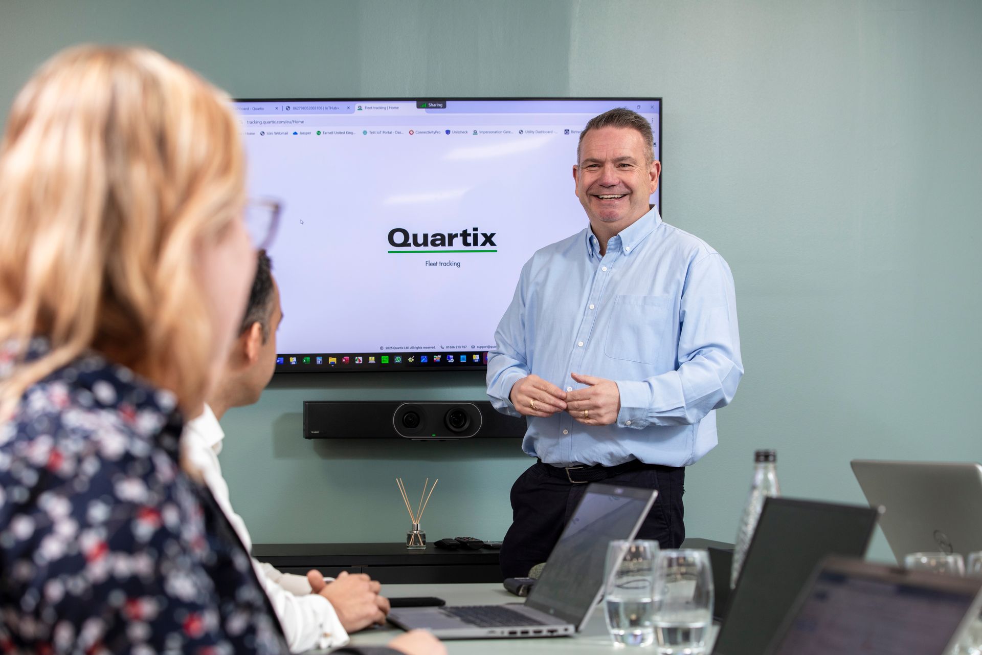 A man is giving a presentation to a group of people in a conference room.