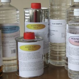 Varios frascos y latas de aceites y glicerina de farmacia en un estante.