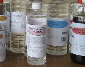 Varias botellas de aceite de cocina en un estante, incluyendo una botella transparente etiquetada como 