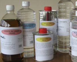 Varias botellas y recipientes de aceite con etiquetas españolas sobre una mesa.
