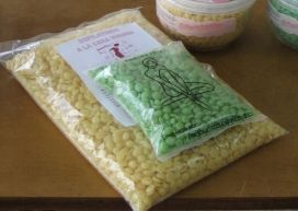 Surtido de caramelos empaquetados sobre una mesa, incluyendo bolsas amarillas y verdes y un recipiente de plástico al fondo.