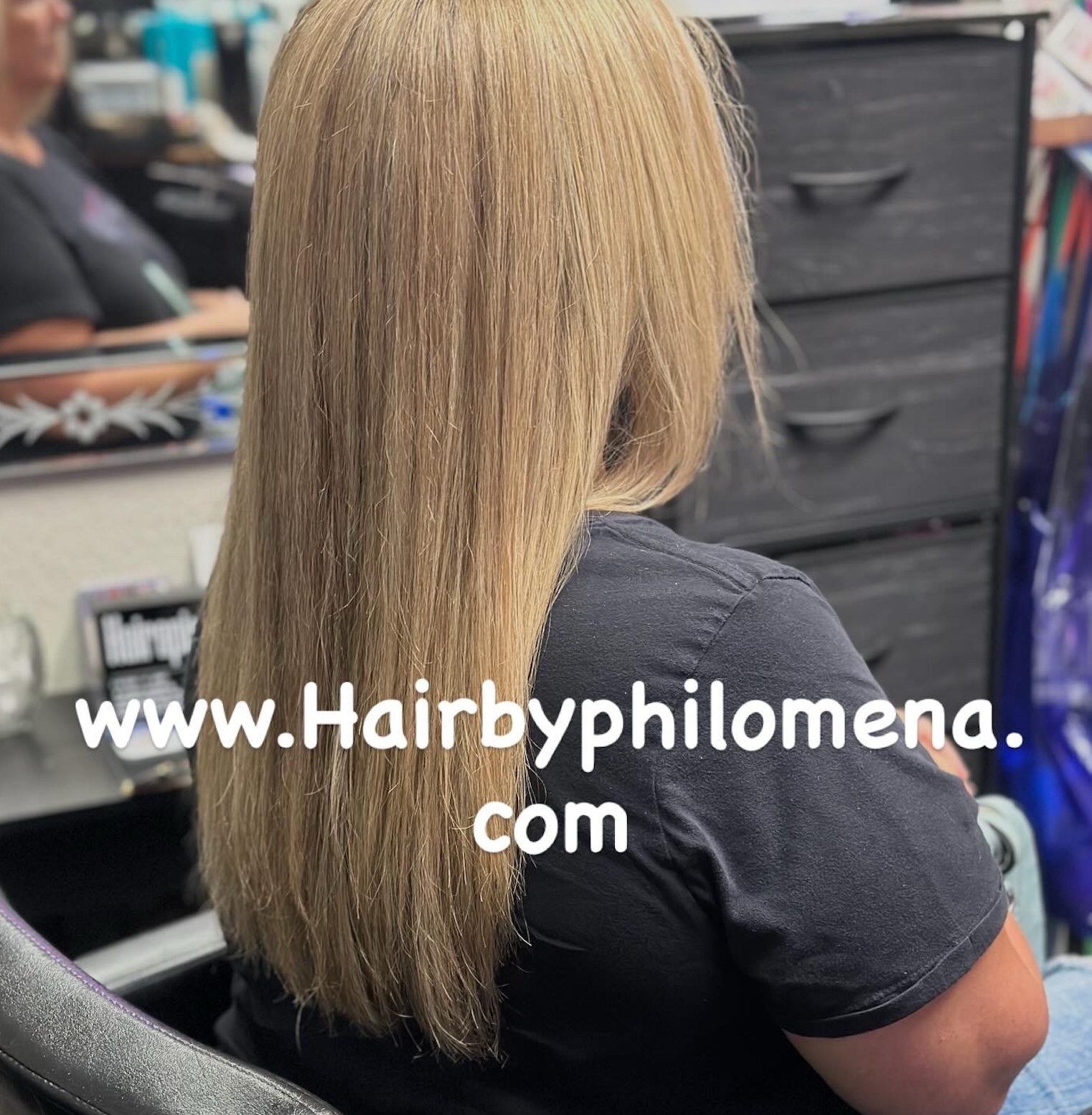 Blonde straight shoulder-length haircut shown from the back in a salon chair, with watermark text.