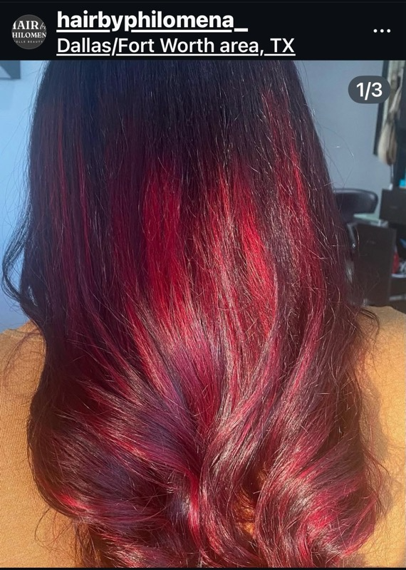 Glossy burgundy-red ombré hair with dark roots, styled in loose waves at a salon in Dallas/Fort Worth.