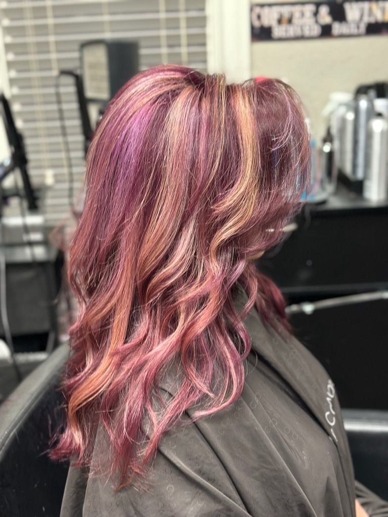 Pink and purple wavy hair styled in a layered bob at a salon sink