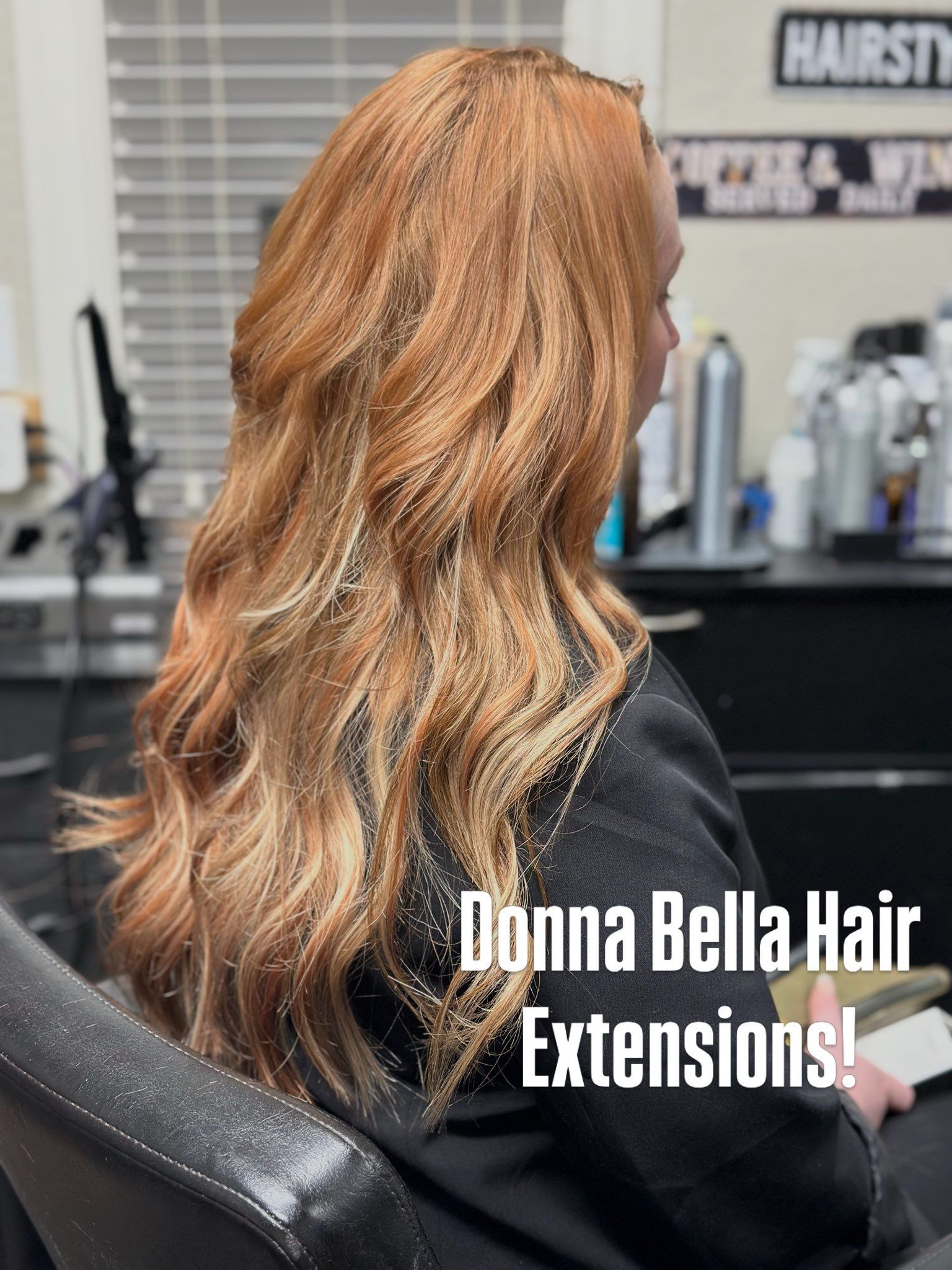 Long wavy copper-blonde hair extensions in a salon chair, with “Donna Bella Hair Extensions” text.