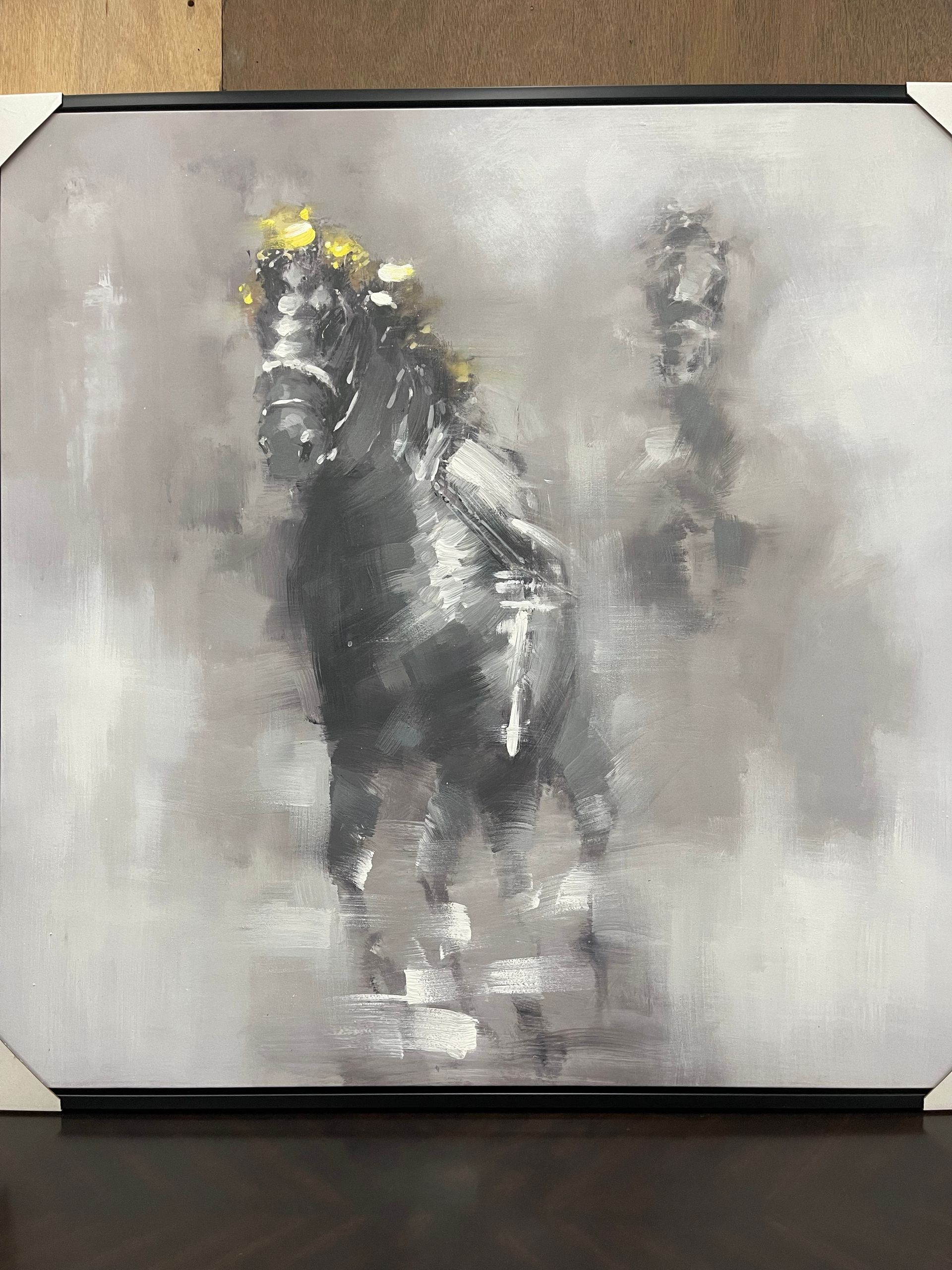 An abstract painting of a dark horse with gold-colored accents on its head, set against a blurred gray and white background.