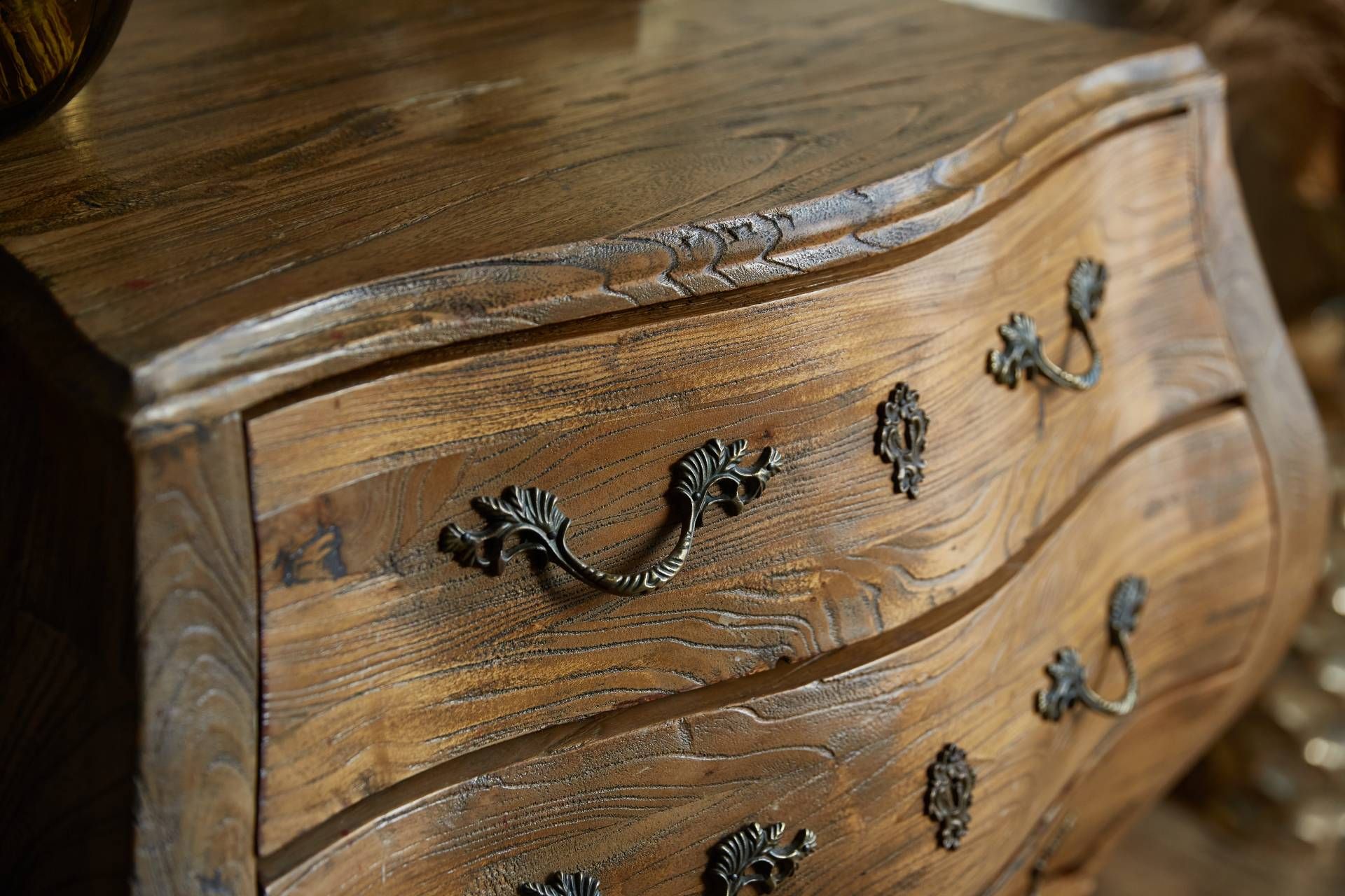 Antique wood dresser with curved drawers and ornate brass pulls near Lexington, KY