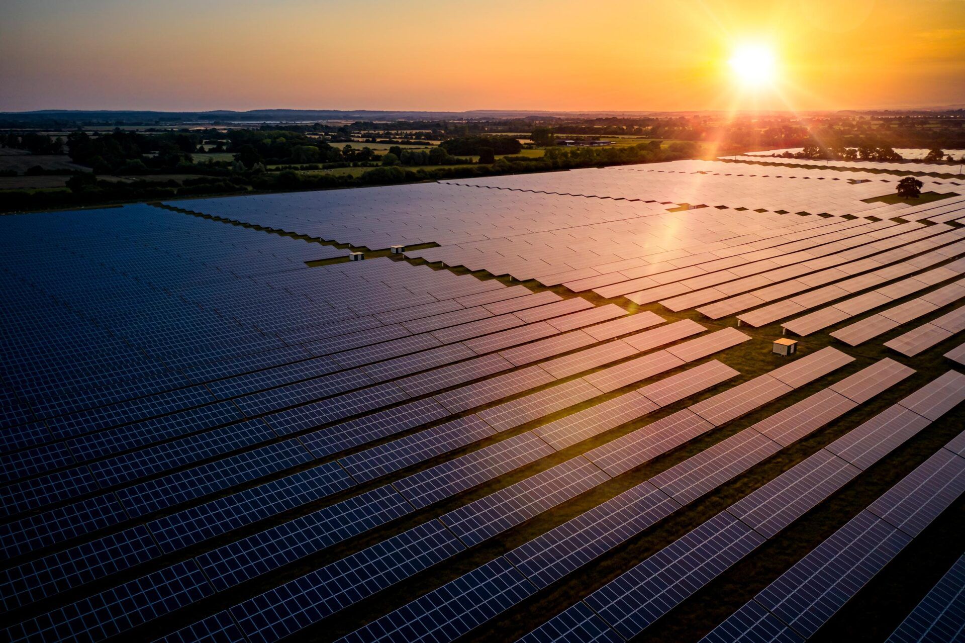 An aerial view of a solar farm at sunset.