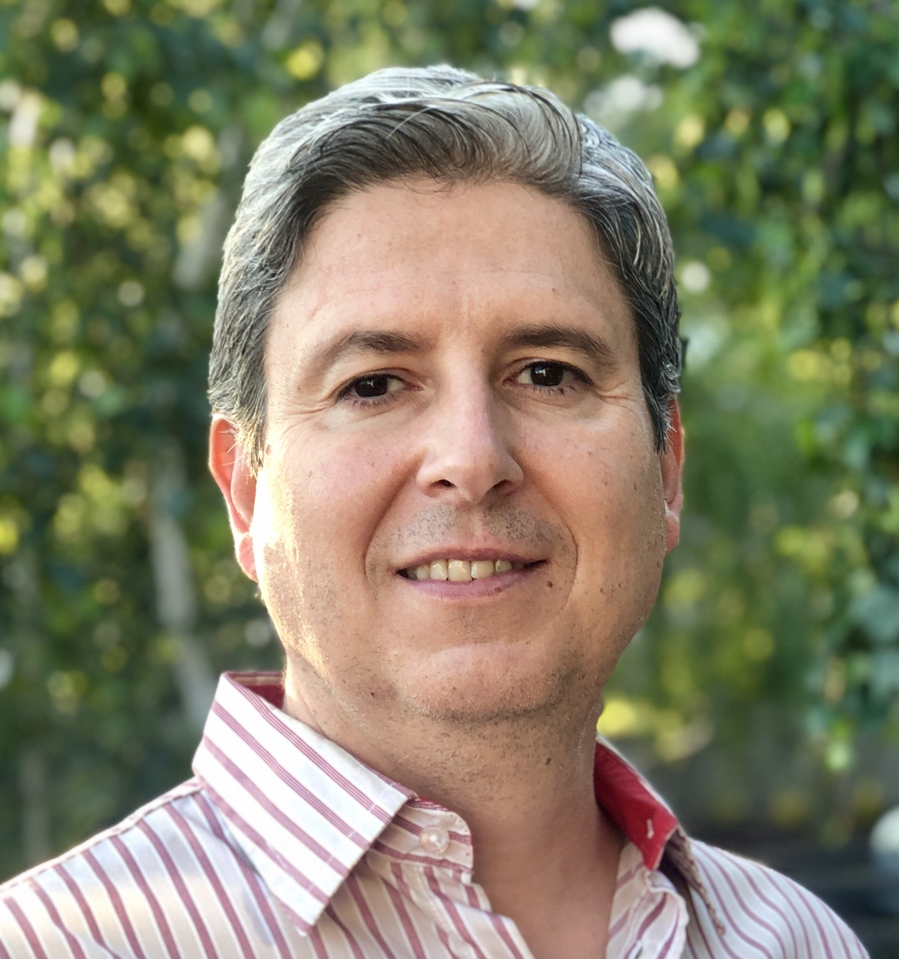 A man in a striped shirt is smiling for the camera.