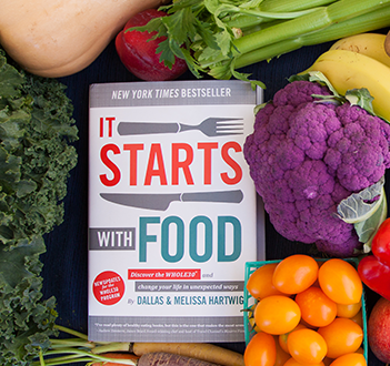A book called it starts with food is surrounded by fruits and vegetables