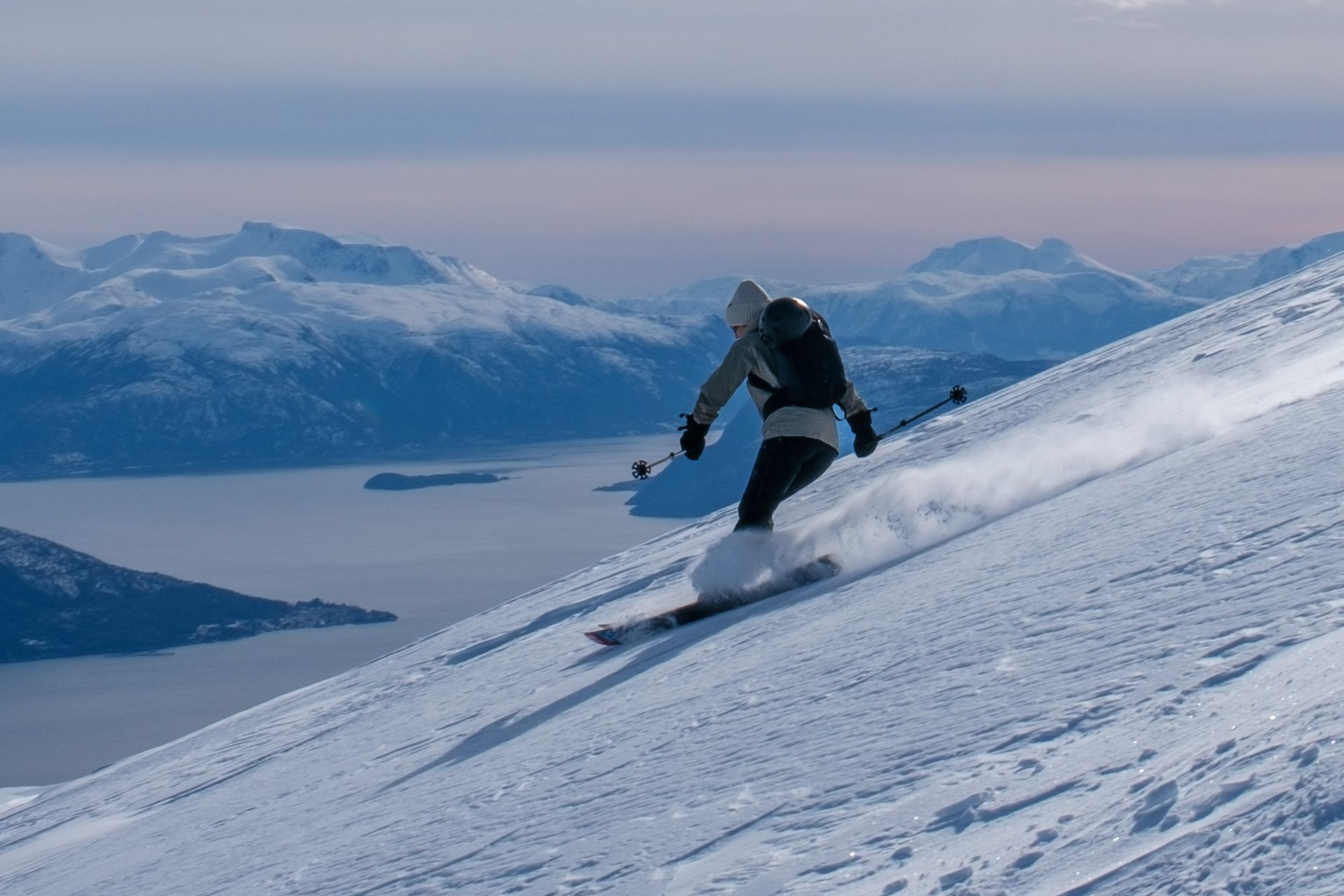 A person skiing down from a mountain in a ski touring trip