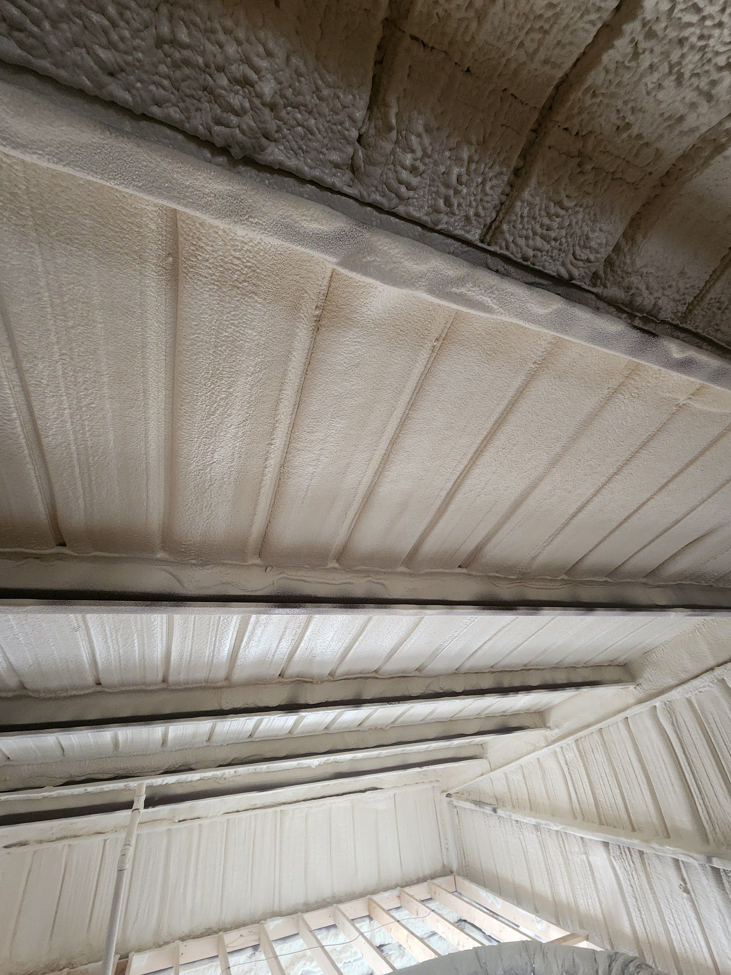 Looking up at a weathered concrete ceiling with beams and a skylight above.