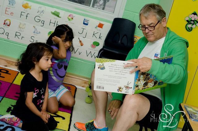 A Man Is Reading a Book to Two Little Girls