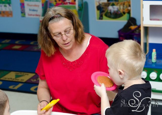 A Woman in A Red Shirt Is Playing with A Child