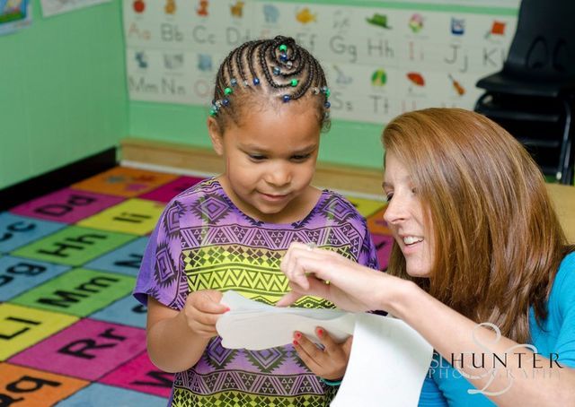 A Woman and A Little Girl Are Looking at A Piece of Paper.