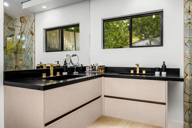 A bathroom with two sinks and a large mirror