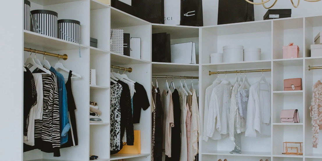 A closet filled with lots of clothes and shoes.