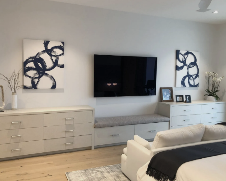 A bedroom with a large flat screen tv on the wall