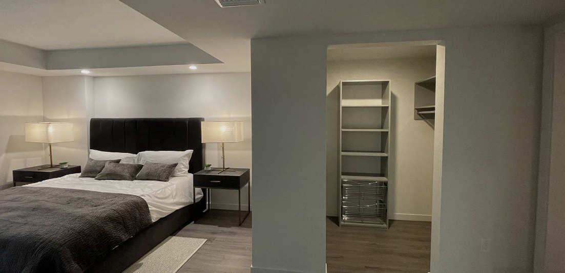 A bedroom with a large bed and a walk in closet.