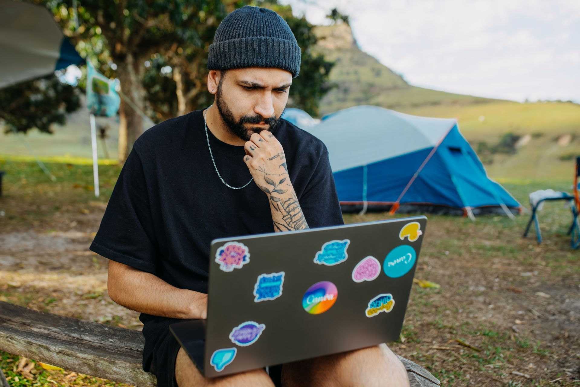 Laptop covered in stickers at a campsite