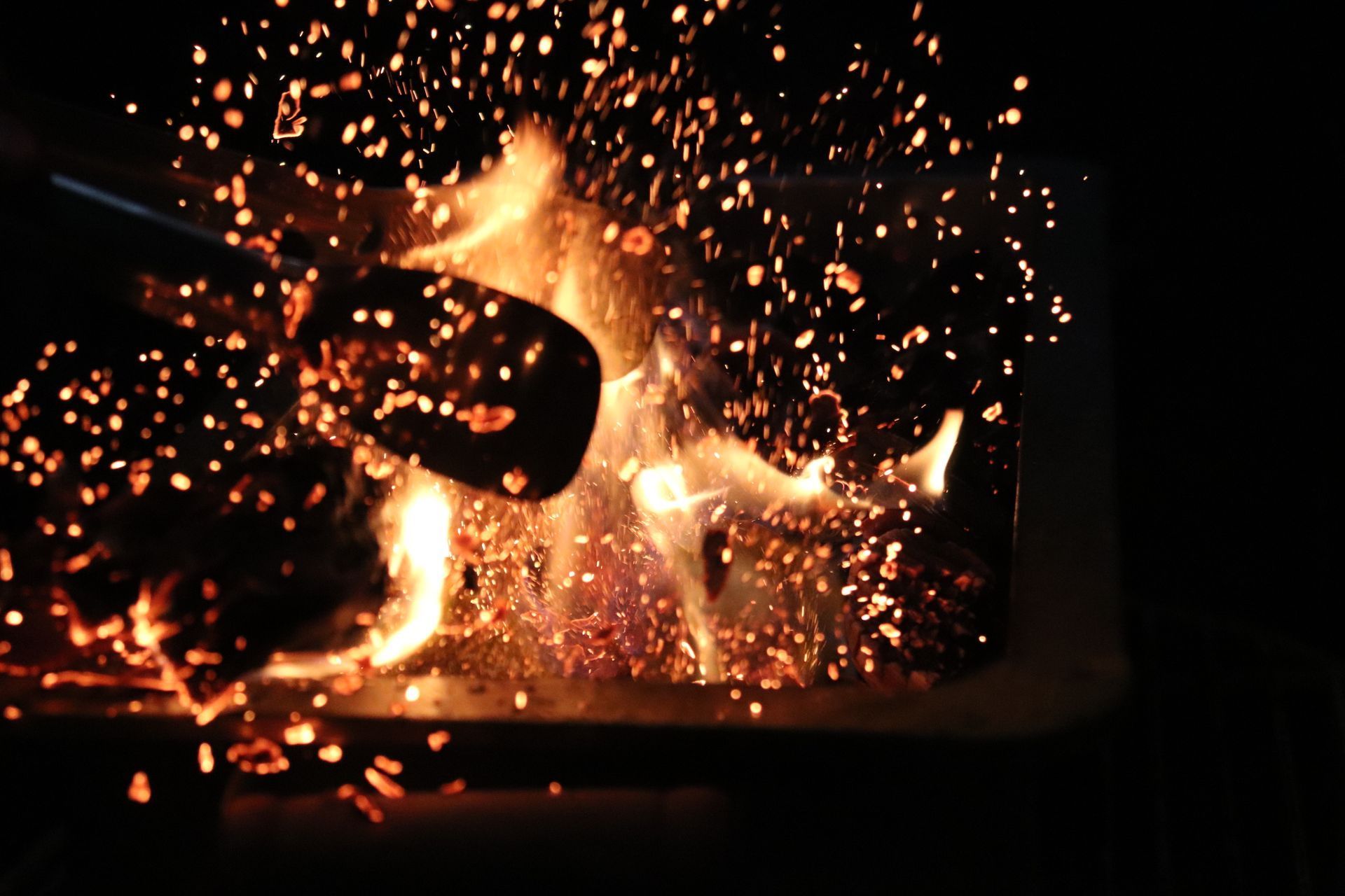 Sparks rising from a fire at night