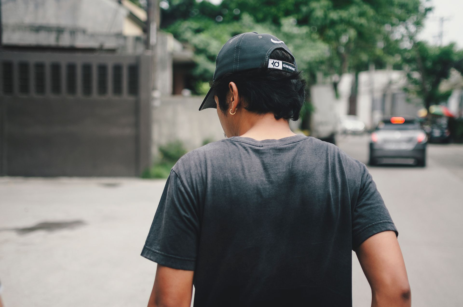 Man in a black cap seen from behind on a city street