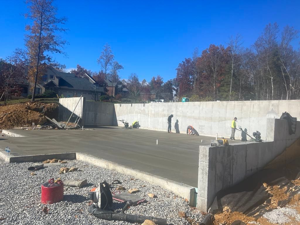A group of construction workers are working on a concrete foundation.
