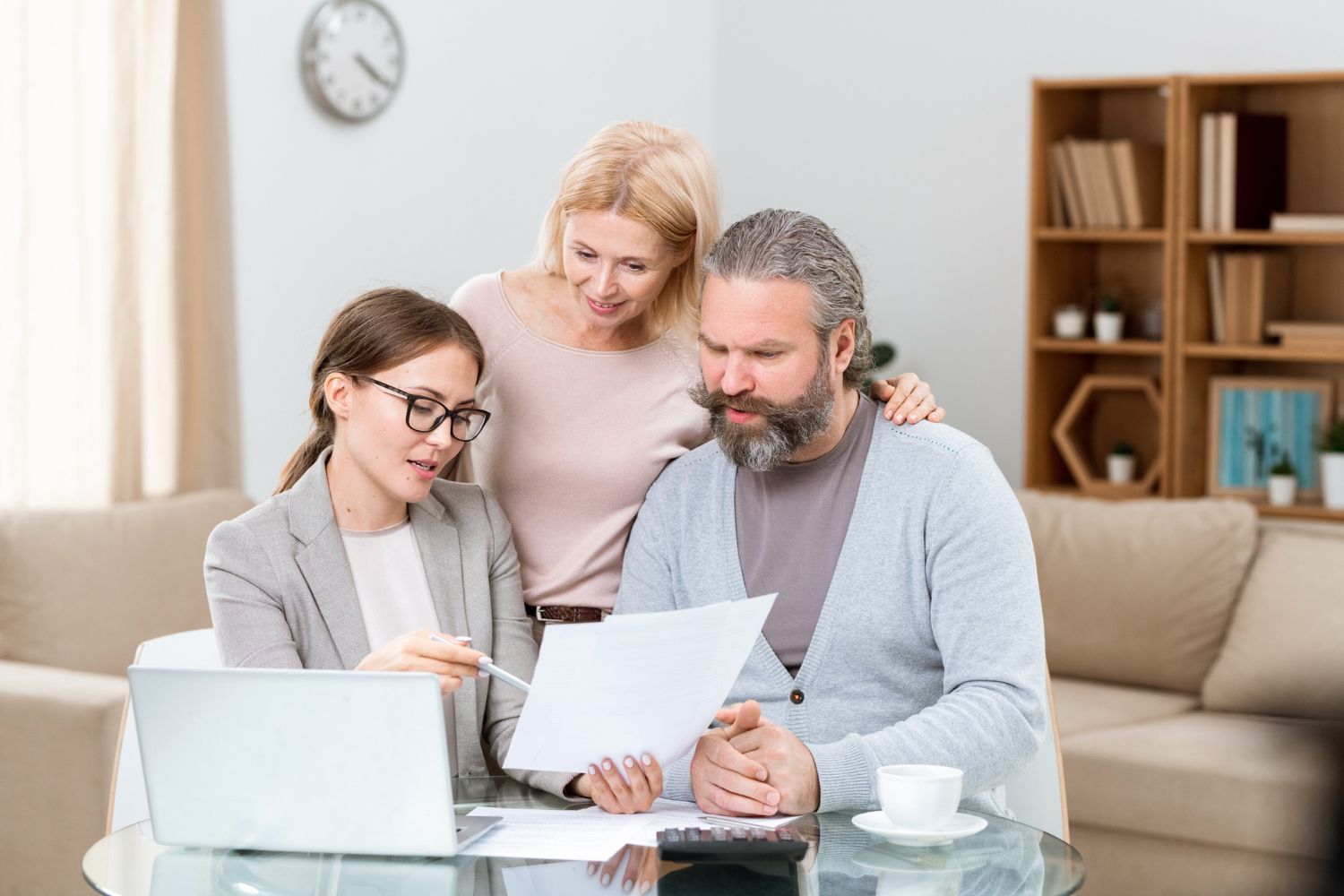 Financial advisor explaining documents to a couple at a table.