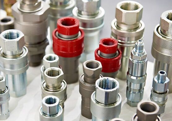 A bunch of different types of hydraulic fittings are sitting on a table.