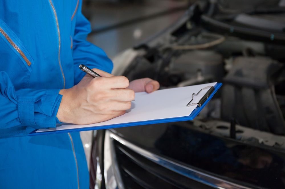Handwriting on a Clipboard Beside a Car With the Hood Open — Van Diemen's Automotive & Electrical Repairs In Bellerive, TAS