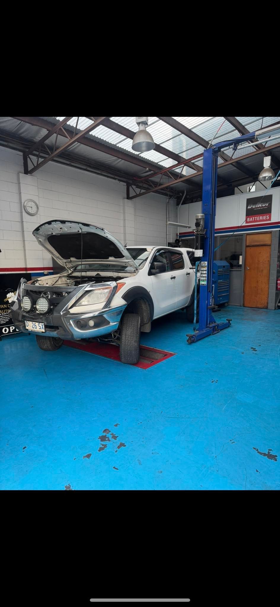 Car in a Garage Repair Bay With Hood Open on a Blue Floor Lift — Van Diemen's Automotive & Electrical Repairs In Bellerive, TAS